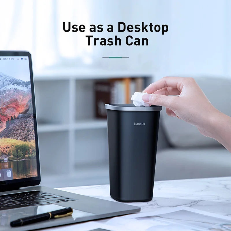 Baseus trash bin used on a desk beside a laptop, demonstrating compact desktop use