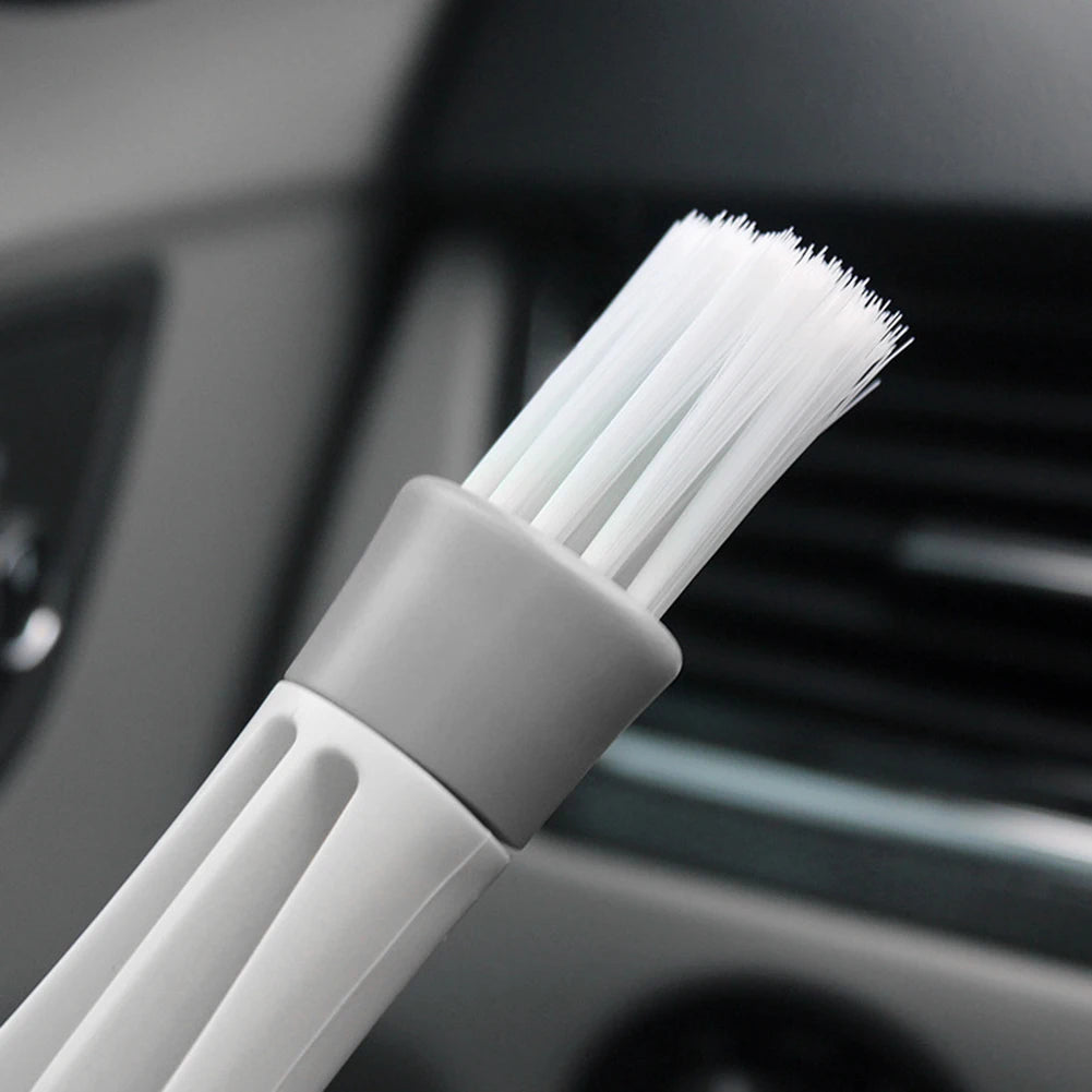 Action shot of dust removal from car vent slats using dual-head microfiber brush