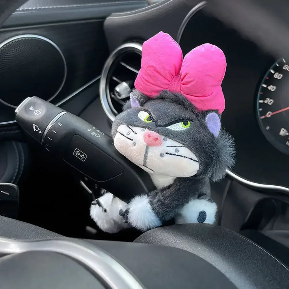 Cat plush toy with pink bow wrapped around car wiper lever as a cute dashboard interior decoration