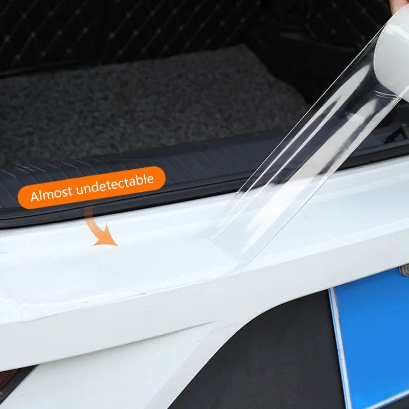 Transparent door sill protection film being applied to car edge, highlighting nearly invisible finish