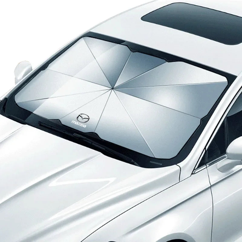 Silver foldable sunshade fully installed on car windshield, viewed from exterior to show full coverage