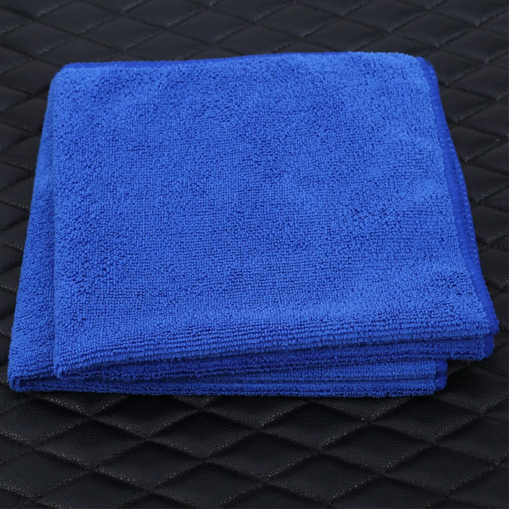 Thick microfiber towel in use on car hood for polishing and wax buffing