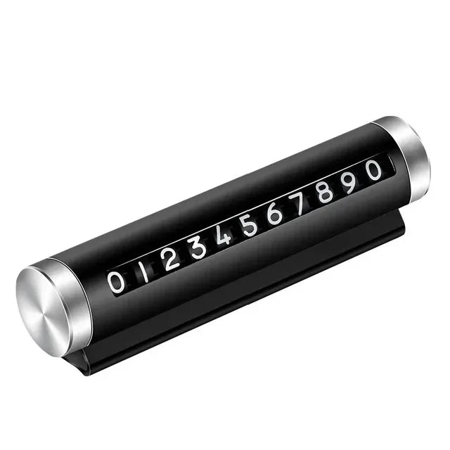 Black metal rotating car parking number plate on white background showing full 0 to 9 digit roller and dashboard stand