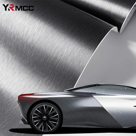 Silver brushed aluminum vinyl wrap sheet curling over a wrapped silver sports car, lifestyle hero shot