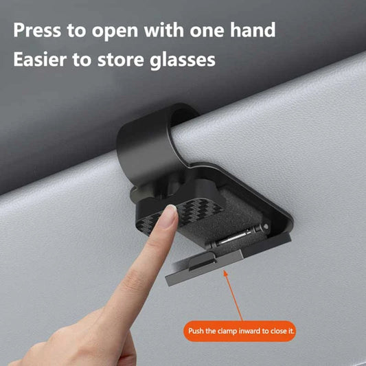 Finger pressing black sun visor glasses clip to open on car sun visor