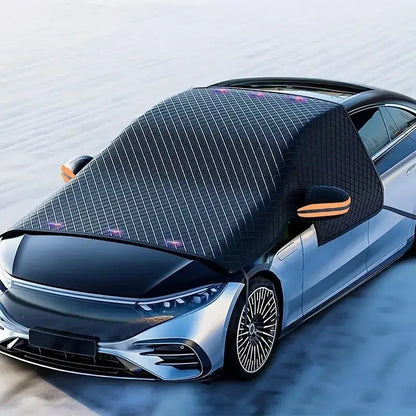 3-layer Oxford windshield cover installed on silver sedan in snowy winter scene with orange reflective mirror covers and 6-magnet secure grip