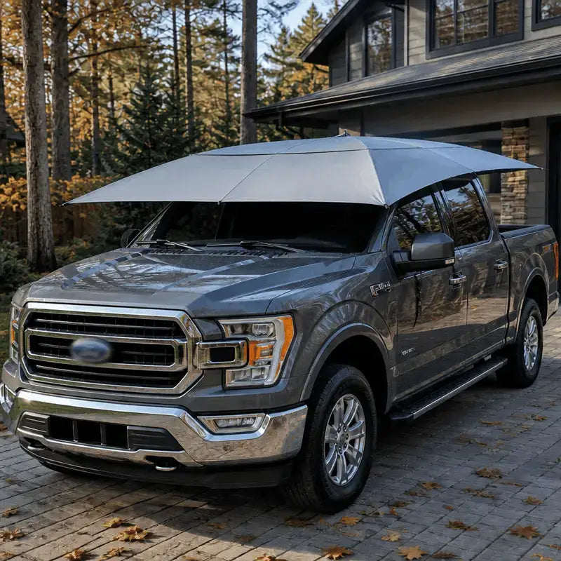 Automatic car umbrella silver gray deployed on gray Ford F-150 pickup truck parked in home driveway autumn setting