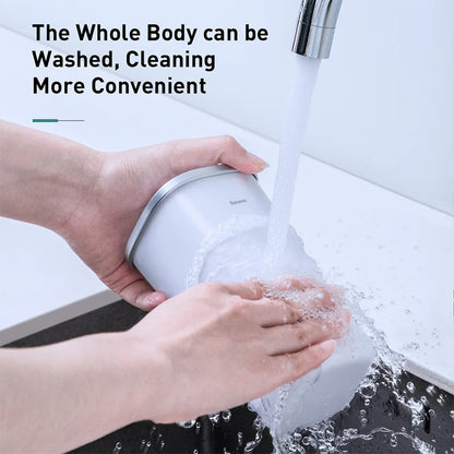 Hands washing the Baseus trash bin under running water, showing its full-body washable design
