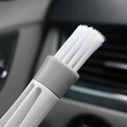 Action shot of dust removal from car vent slats using dual-head microfiber brush