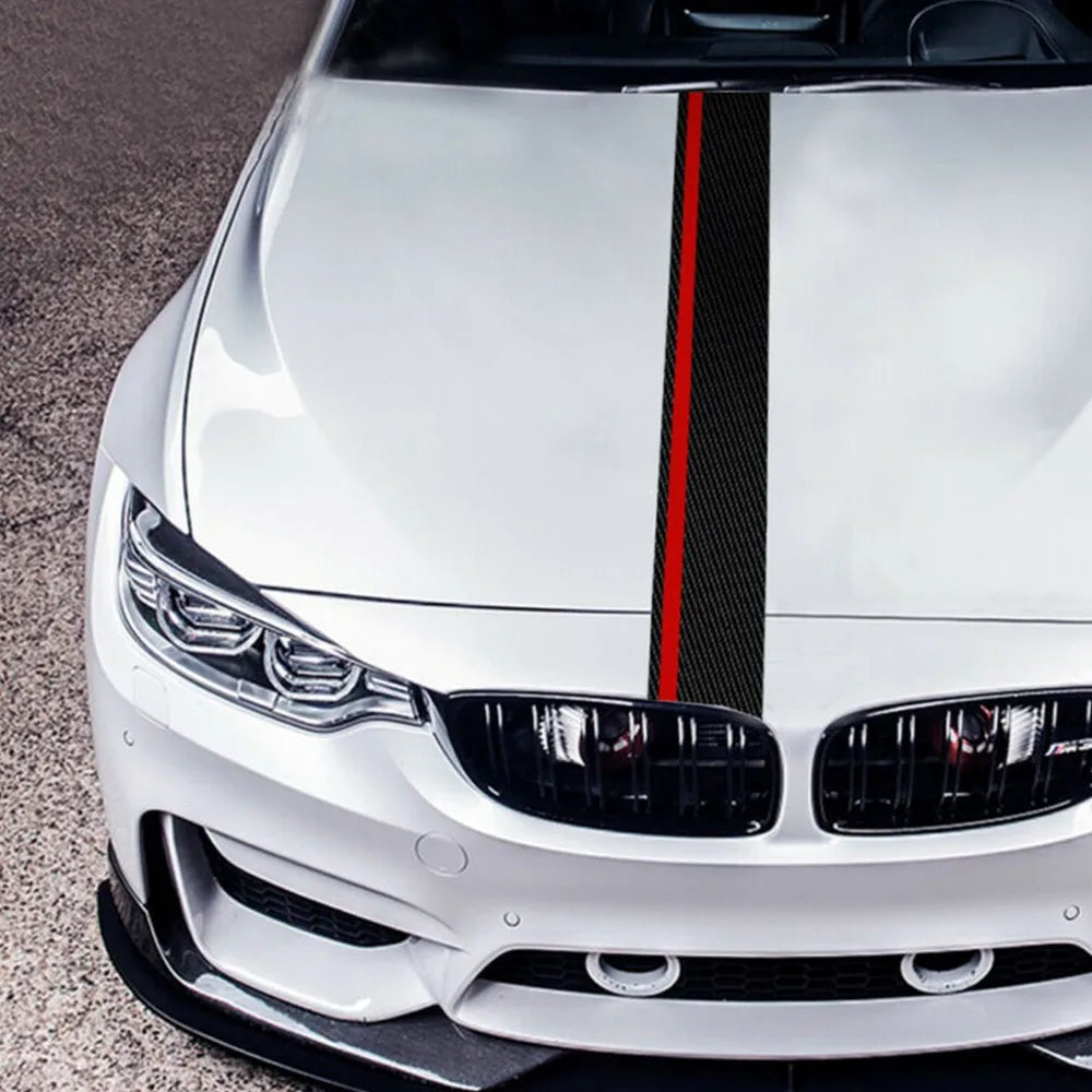 Carbon fiber rally stripe decal applied centrally on white BMW M4 hood viewed from front