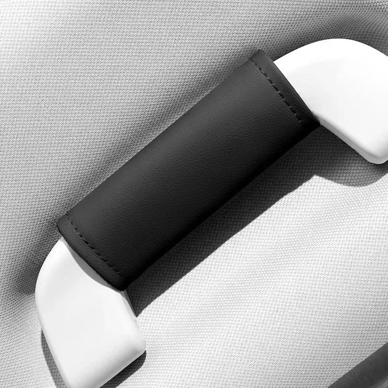 Single black leather-look car roof handle cover installed on grab handle, close-up product shot