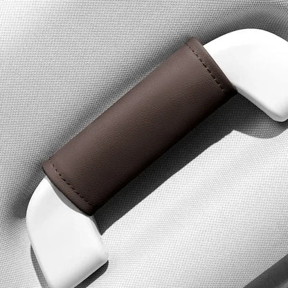 Single brown leather-look car roof handle cover installed on grab handle, close-up product shot