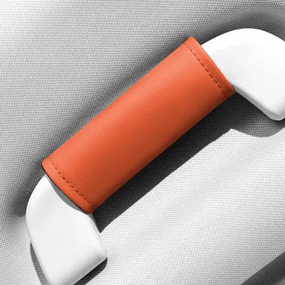 Single orange leather-look car roof handle cover installed on grab handle, close-up product shot