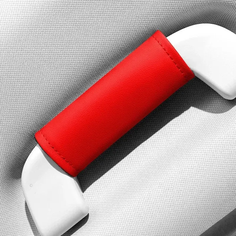 Single red leather-look car roof handle cover installed on grab handle, close-up product shot