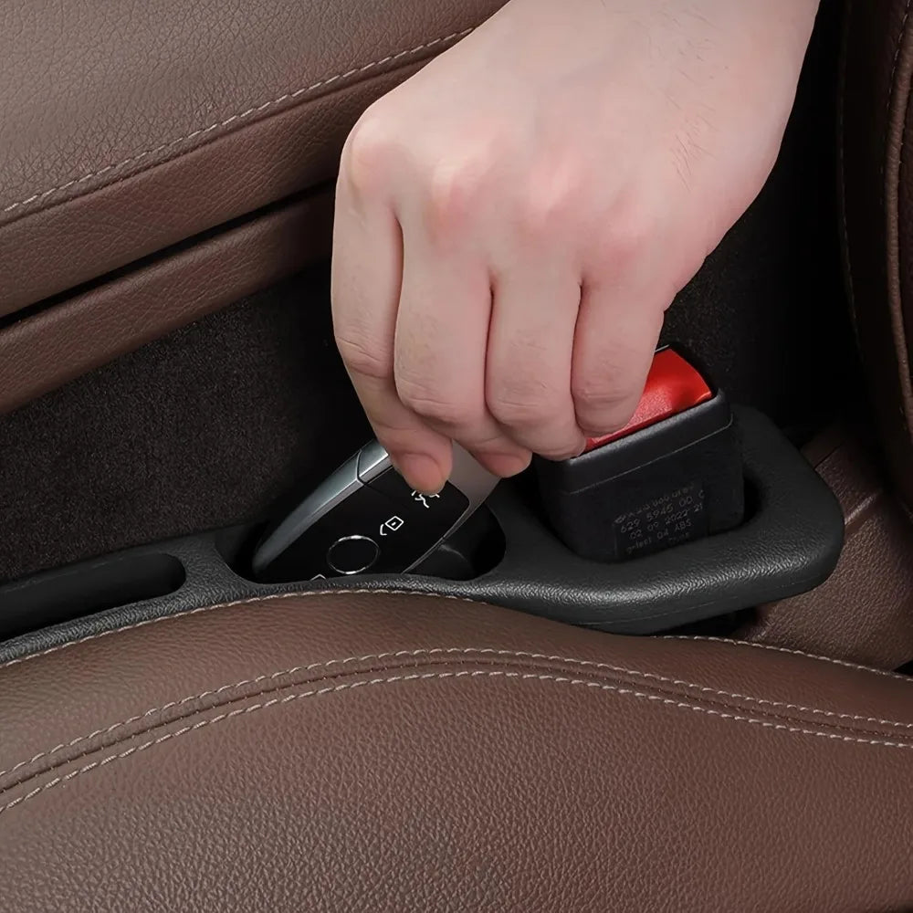 Hand retrieving car key from seat gap filler organizer groove