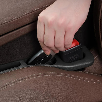 Hand retrieving car key from seat gap filler organizer groove
