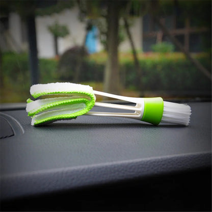 Double-ended car vent cleaning brush resting at angle on dark car dashboard