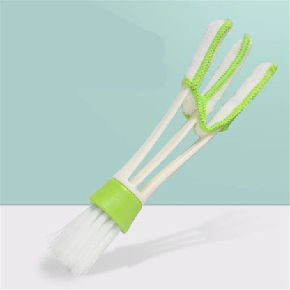 Double-ended vent cleaning brush showing microfiber finger slots and bristle brush end on teal background