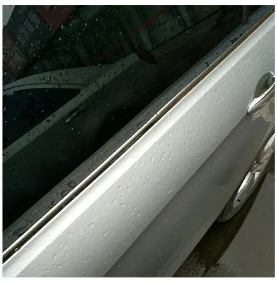 Rubber weatherstrip installed on white car door window channel with rain droplets visible