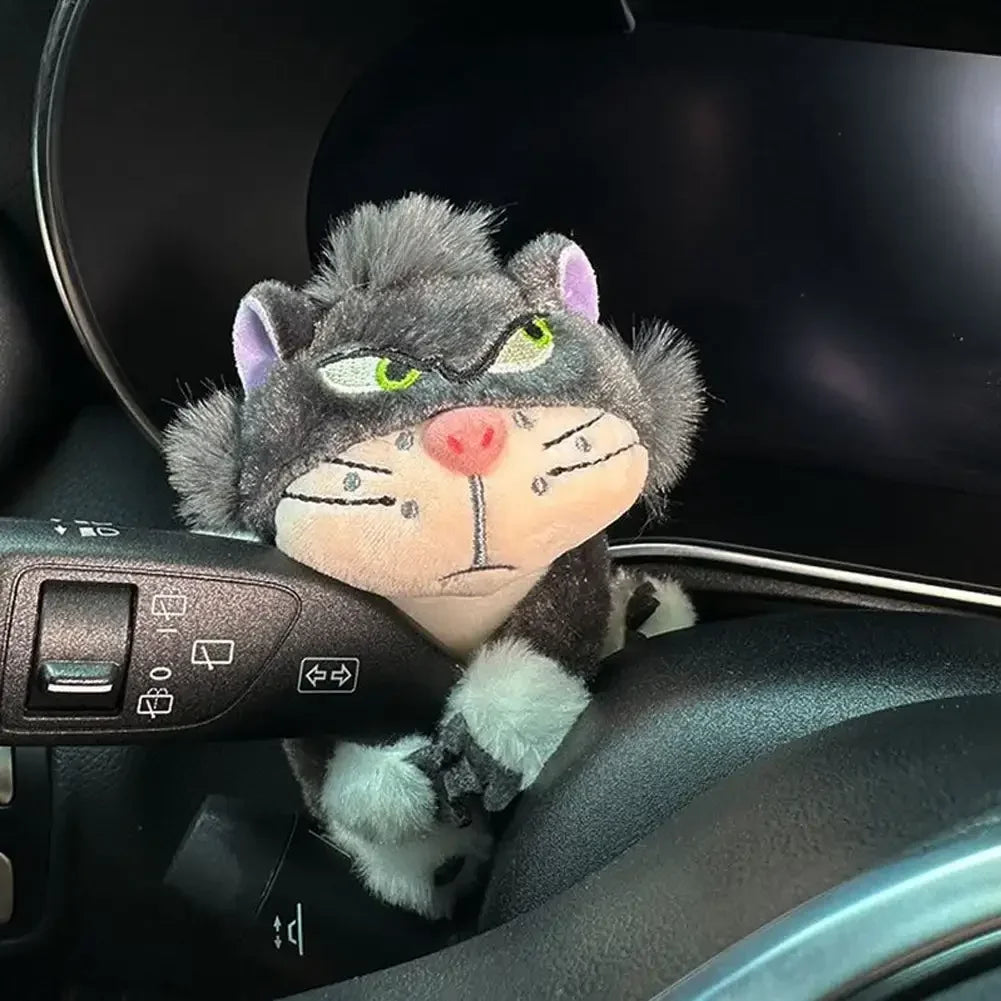 Gray cat plush toy clipped onto car turn signal lever as a cute dashboard accessory