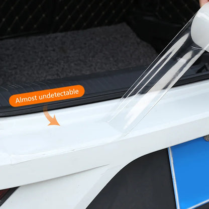 Transparent door sill protection film being applied to car edge, highlighting nearly invisible finish