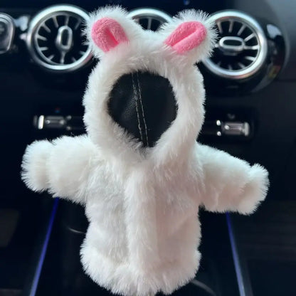 Cute white rabbit cartoon plush gear shift cover installed on gear lever in Mercedes interior with pink ears outstretched arms and blue ambient lighting