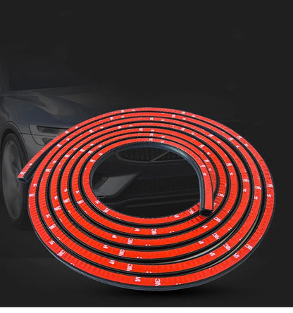Coiled D-type EPDM rubber door seal strip with red 3M adhesive on dark background