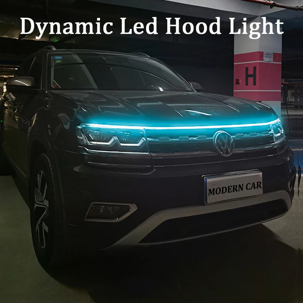 Dynamic LED DRL hood light strip glowing ice blue along front grille edge of dark VW Tiguan at night