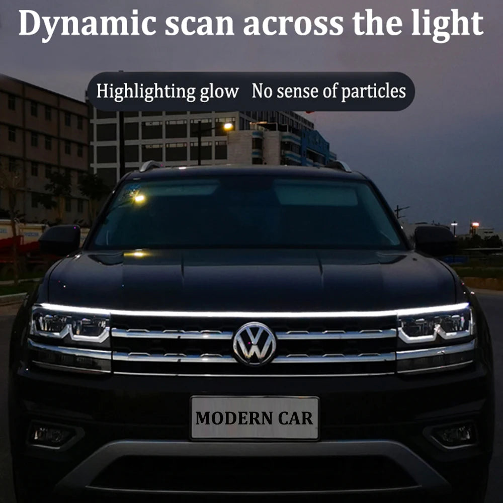 Dynamic scan LED DRL hood light strip glowing white across full width of VW Tiguan front hood at dusk