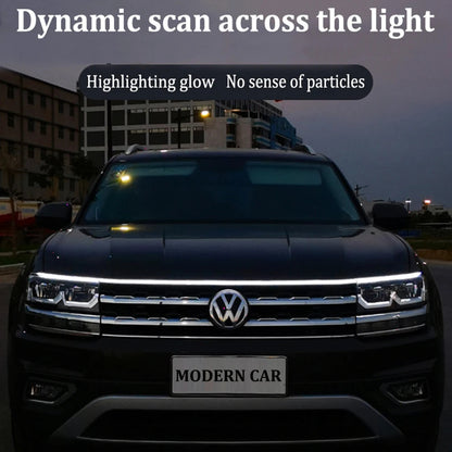 Dynamic scan LED DRL hood light strip glowing white across full width of VW Tiguan front hood at dusk