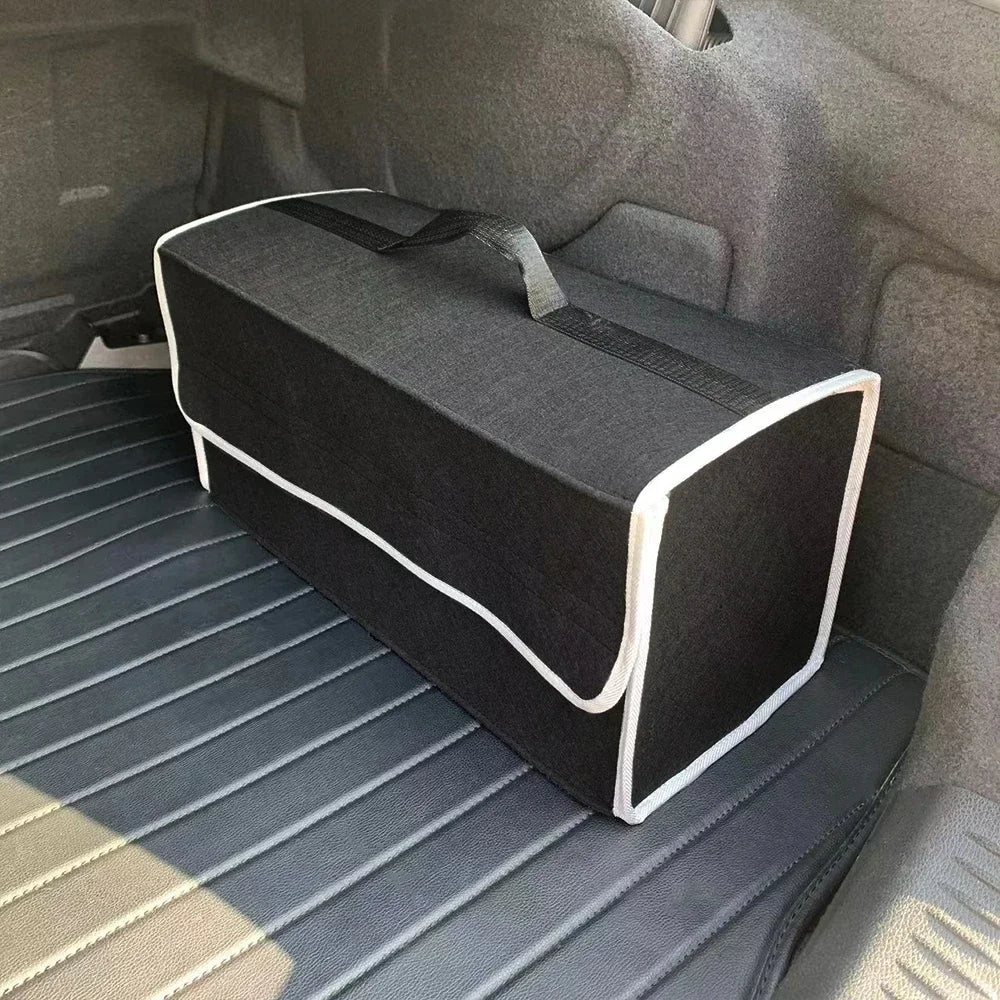 Black felt trunk organizer with white trim edge placed in car cargo area on leather mat