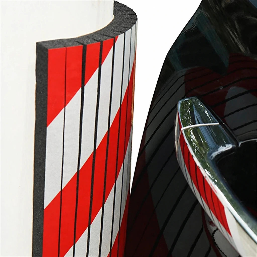 Red and white foam garage wall bumper guard close-up with car door handle reflection