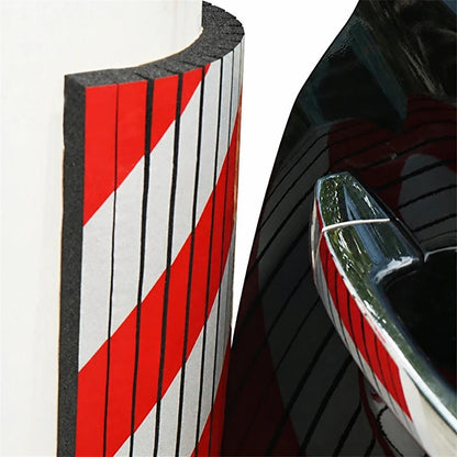 Red and white foam garage wall bumper guard close-up with car door handle reflection