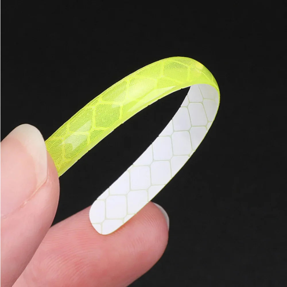 Curved green reflective wheel stripe showing flexible adhesive backing for easy installation