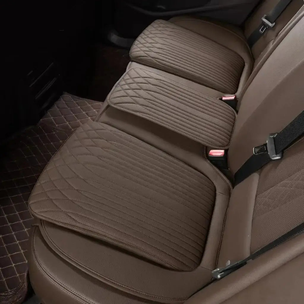 Brown leather car seat height cushion installed on rear seat showing thick padded profile and perforated surface