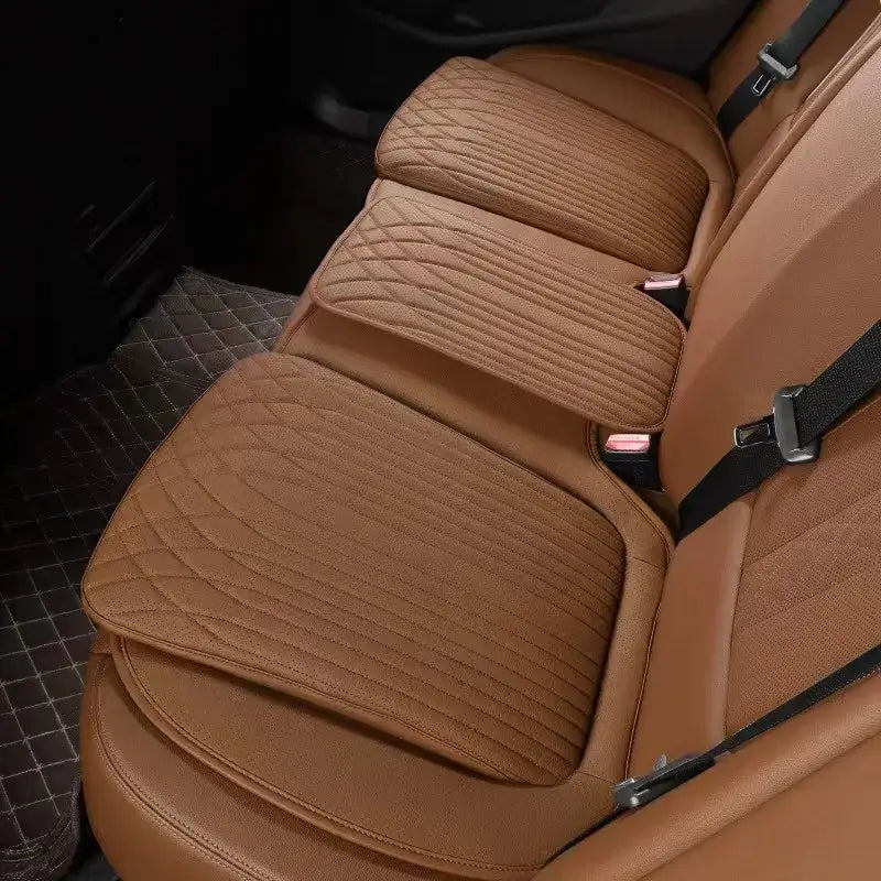 Orange leather car seat height cushion installed on rear seat showing thick padded profile and perforated surface