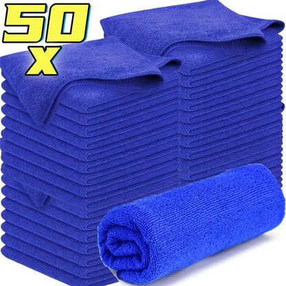 Stack of 50 blue microfiber car cleaning cloths with one towel rolled in front