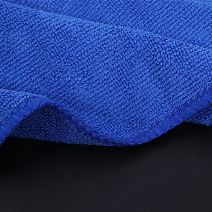 Blue microfiber towel folded and draped showing thick plush texture on dark background