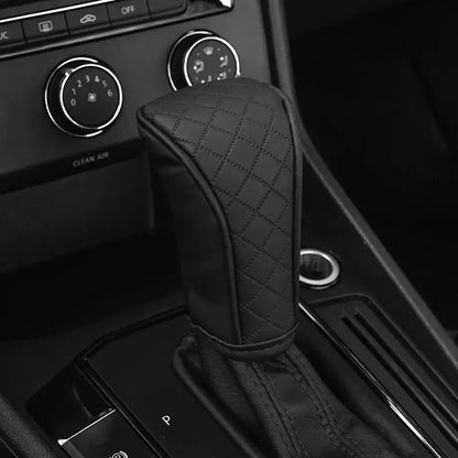 Black quilted PU leather gear shift gaiter cover installed on Volkswagen automatic gear selector in dark car interior showing clean diamond stitch pattern and snug universal fit