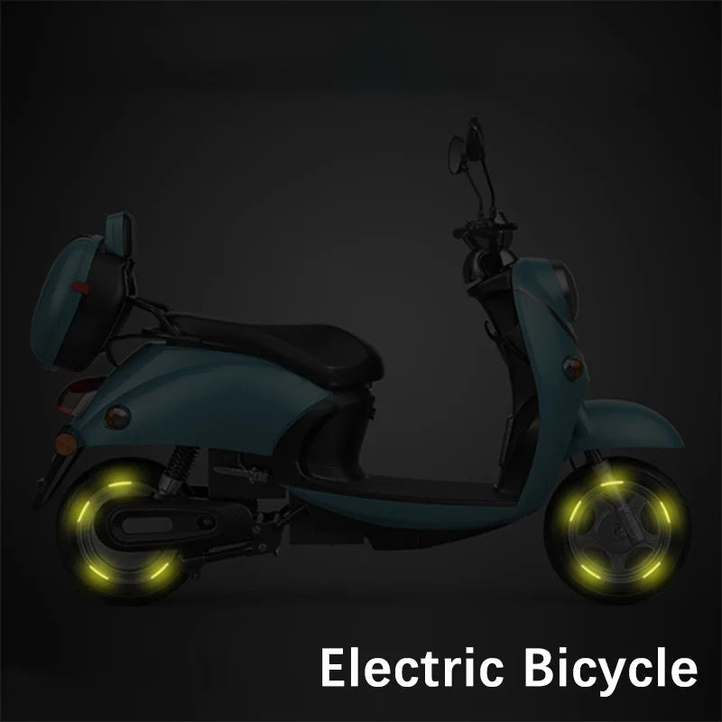 Yellow reflective wheel hub stickers glowing on electric scooter tires at night