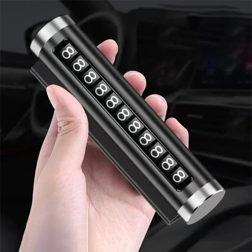 Black metal rotating car parking number plate held in hand at angle with car interior background