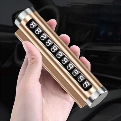 Gold metal rotating car parking number plate held in hand at angle with car interior background