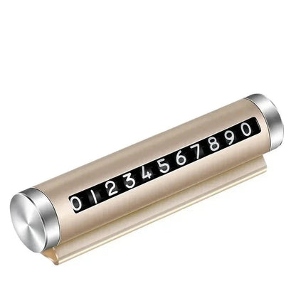 Gold metal rotating car parking number plate on white background showing full 0 to 9 digit roller and dashboard stand
