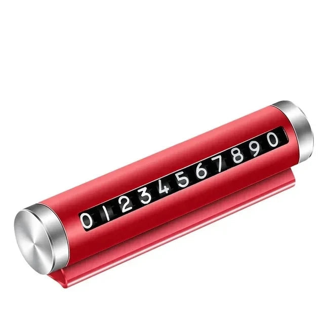 Red metal rotating car parking number plate on white background showing full 0 to 9 digit roller and dashboard stand