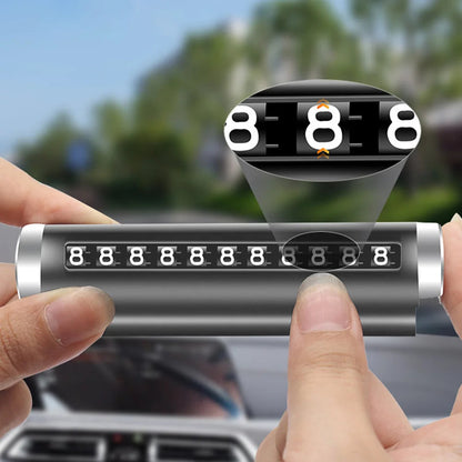 Hands holding black rotating parking number plate with magnified inset showing individual rotating digit mechanism