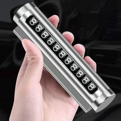 Silver metal rotating car parking number plate held vertically in hand with car interior in background