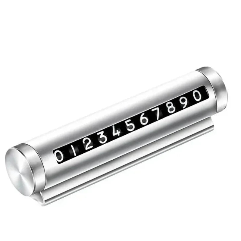 Silver metal rotating car parking number plate on white background showing full 0 to 9 digit roller and dashboard stand