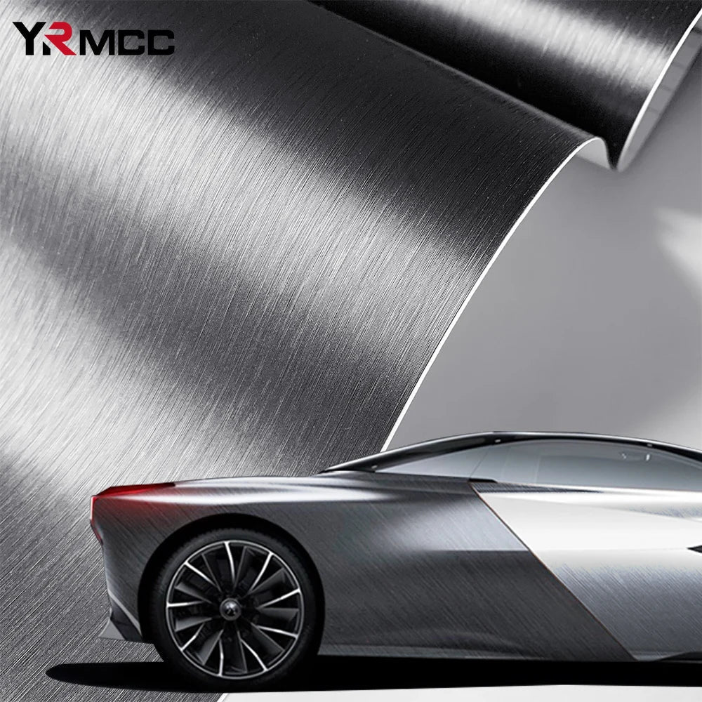 Silver brushed aluminum vinyl wrap sheet curling over a wrapped silver sports car, lifestyle hero shot