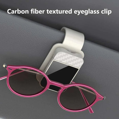 Beige carbon fiber textured sun visor eyeglass clip holding pink sunglasses