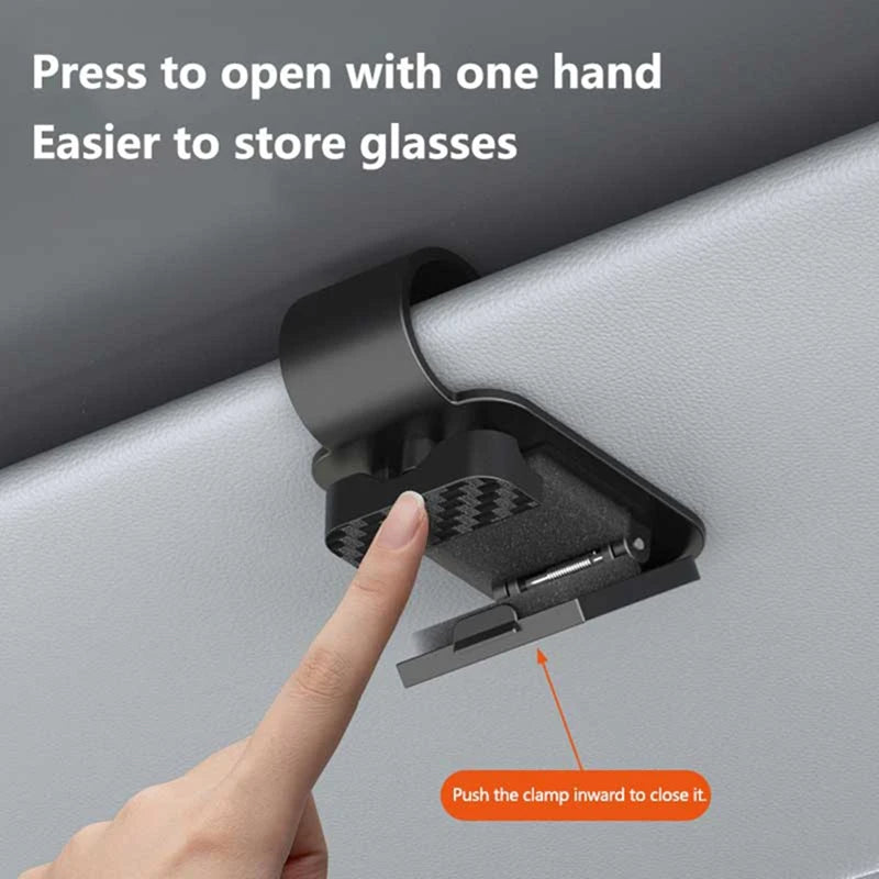 Finger pressing black sun visor glasses clip to open on car sun visor